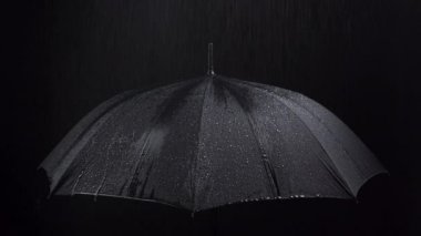 Siyah şemsiye ve yağmur damlalarının siyah arkaplanda görüntüsü