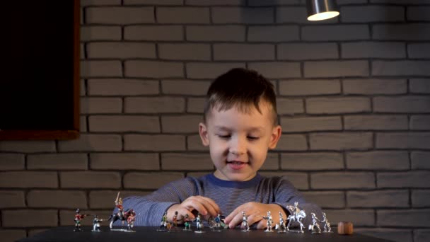 Beelden van een vierjarige jongen die met tinnen soldaten speelt — Stockvideo
