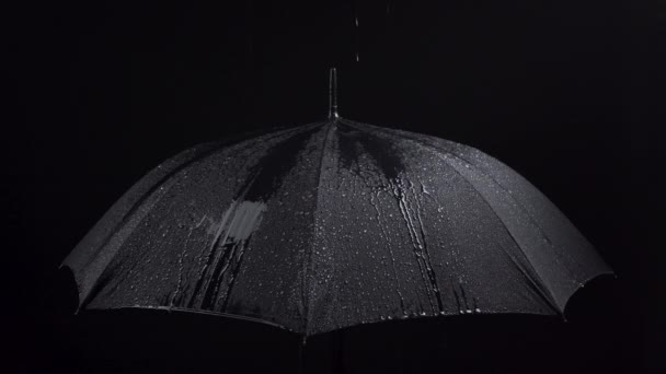 Съемки зонтика и дождевых капель на черном фоне — стоковое видео