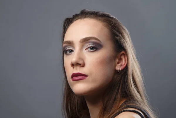 Mujer joven con labios morados sobre fondo gris — Foto de Stock