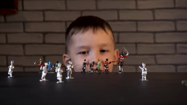 Четырехлетний ребенок играет с оловянными солдатами — стоковое видео
