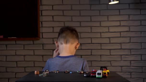 Четырехлетний мальчик играет с оловянными солдатами и машинами — стоковое видео