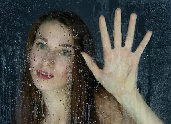 Foto di ragazza che tocca il vetro con gocce d'acqua — Foto Stock