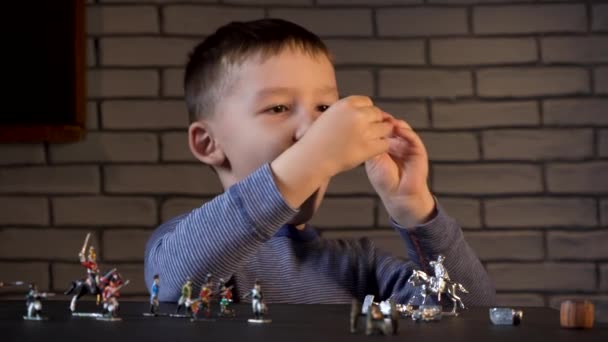 Filmagem de um garoto de quatro anos brincando com soldados de estanho — Vídeo de Stock