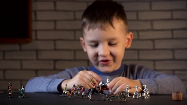 Schieten van kleine brunette jongen spelen met tin soldaten — Stockvideo