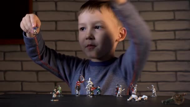 Imágenes de un niño de cuatro años jugando con soldados de hojalata hechos a mano — Vídeo de stock