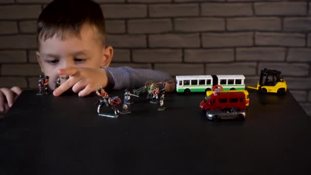 Βίντεο ενός τετράχρονου παιδιού που παίζει με τενεκεδένιους στρατιώτες και αυτοκίνητα — Αρχείο Βίντεο