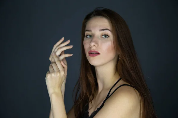 Shot of young brunette woman with long hair on dark background — Stock Photo, Image