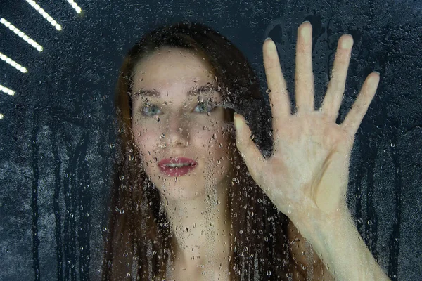 Colpo di ragazza che tocca vetro con gocce d'acqua — Foto Stock
