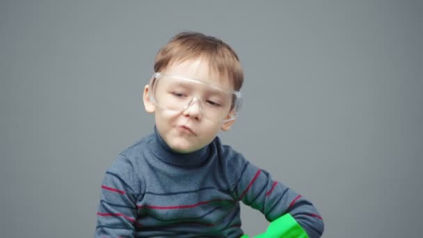 Filmación de un niño de cuatro años con guantes y gafas protectoras — Vídeo de stock