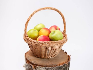 Ağaç kütüğün üzerinde kırmızı ve yeşil elma sepeti