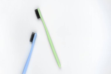 İzole edilmiş beyaz arkaplanda yeşil ve mavi diş fırçalarının resmi