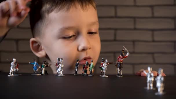 Imágenes de un niño de cuatro años jugando con soldados de hojalata — Vídeo de stock