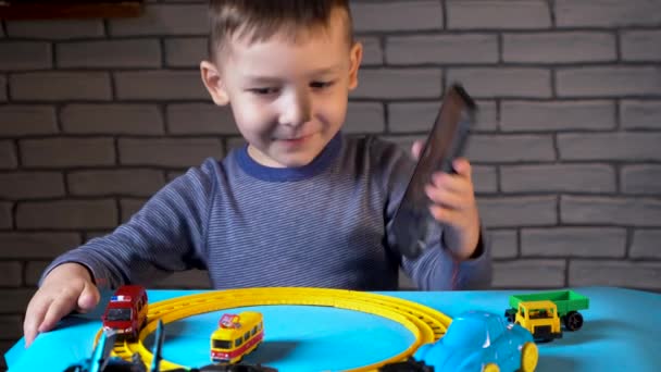 Video hovor čtyřletého chlapce, který si hraje s malými autíčky — Stock video