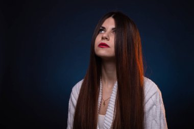 Fotoğrafta uzun saçlı ve kırmızı dudaklı esmer bir kadın var.