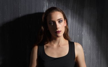 Gri arka planda gölgeli genç kız