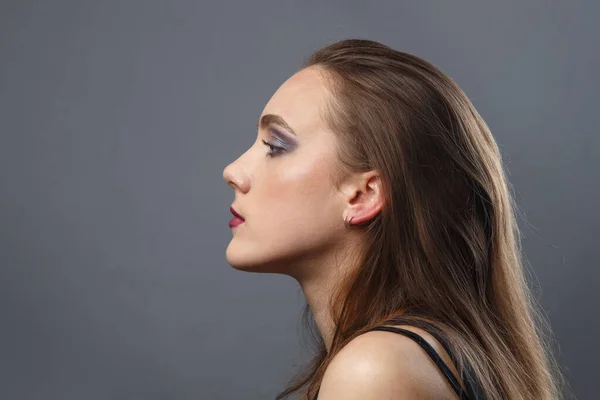 Photo of young woman in profile on grey background — Stock Photo, Image