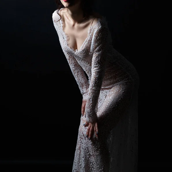 Jonge vrouw in doorzichtige jurk op donkere achtergrond — Stockfoto