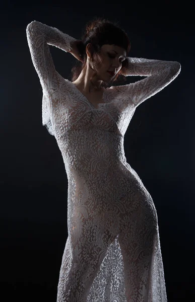 Image of young woman in see-through dress with hands up
