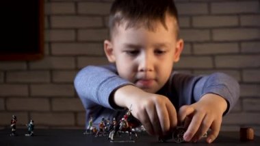 Dört yaşındaki bir çocuğun el yapımı teneke askerlerle oynaması.