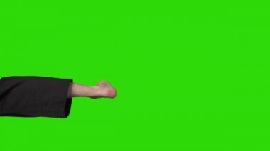 Yeşil arka planda bacağını tekmeleyen adamın videosu