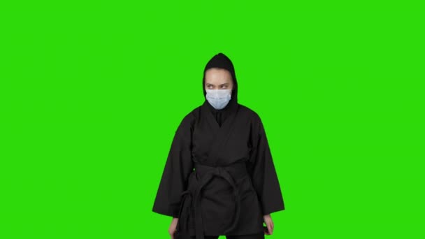 Video av kämpande kvinna i svart kostym ninja på grön isolerad bakgrund — Stockvideo