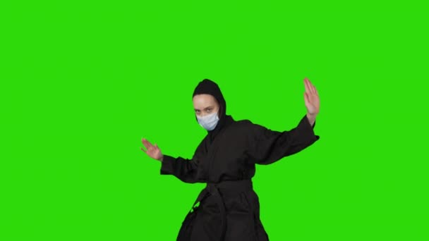 Tir de femme en costume noir ninja sur fond vert isolé — Video