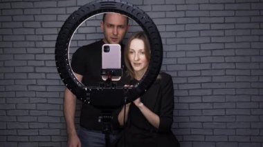 Blogcu çiftin tuğla duvar arka planında hikaye anlattığı video.