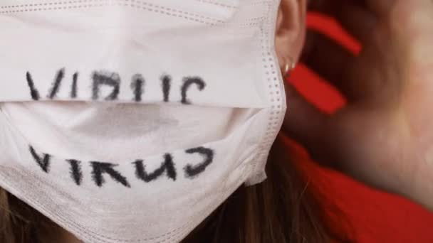 Video af kvinde dressing medicinsk maske på rød baggrund – Stock-video