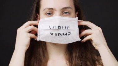 Siyah arka planda tıbbi maske takan bir kadının vurulması