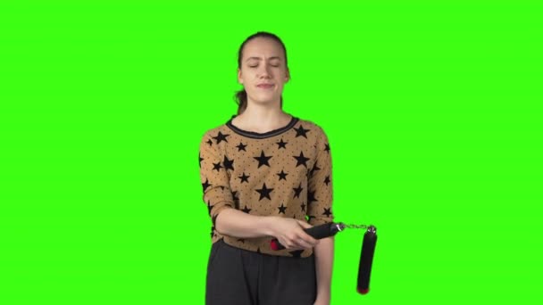 Video de mujer principiante con nunchucks sobre fondo verde aislado — Vídeo de stock