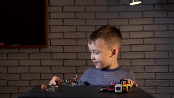 Vídeo de un niño de cuatro años jugando con soldados de hojalata y coches — Vídeos de Stock