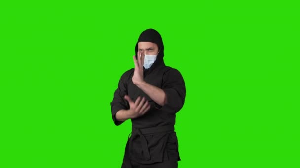 Tiro de homem em preto traje ninja no fundo verde — Vídeo de Stock