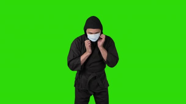 Video av man i svart kostym ninja dressing medicinsk mask — Stockvideo