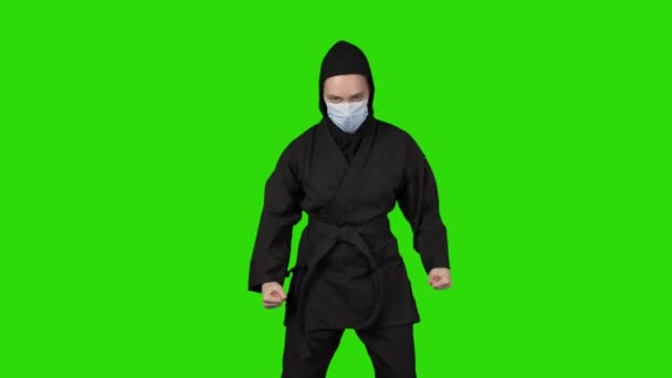 Πλάνα της γυναίκας σε μαύρο κοστούμι ninja σε απομονωμένο φόντο — Αρχείο Βίντεο
