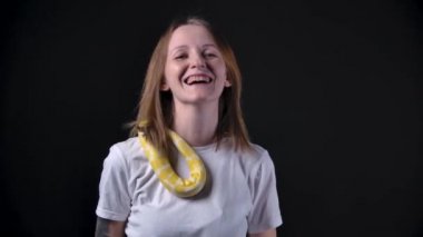 Elinde akıllı telefon tutan albino pitonu olan mutlu bir kadının yavaş çekim videosu.