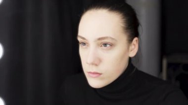 Aynanın önünde koruyucu maske takan bir kadın görüntüsü.