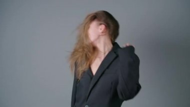 Siyah ceketli, titrek saçlı kadının ağır çekim çekimi.