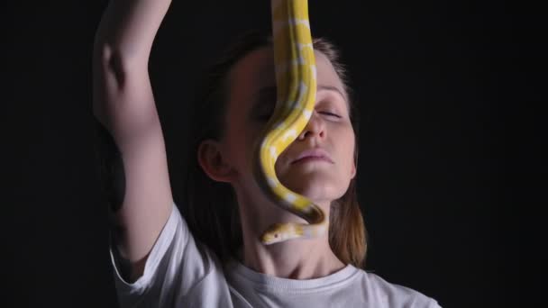 Slow motion footage of woman with python albino crawling on her face — Stock Video