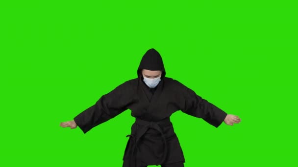 Bojující žena v černém kostýmu ninja na zeleném izolovaném pozadí — Stock video