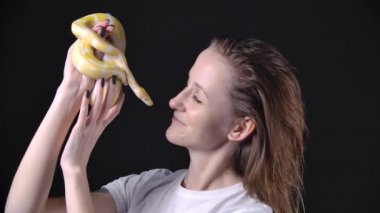 Kadının en sevdiği evcil hayvan olan albino pitonu ağır çekim görüntüsü.