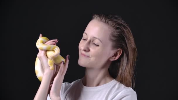 Filmik z kobietą trzymającą ulubionego zwierzaka - albinos python — Wideo stockowe