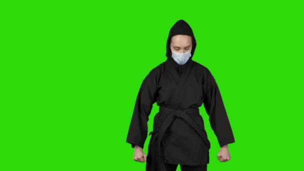 Vídeo de mulher em preto traje ninja no fundo verde isolado — Vídeo de Stock
