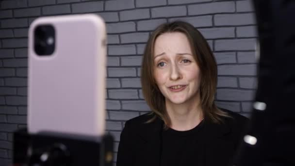 Blogcu kadının tuğla duvarda lambayla hikaye çekmesi — Stok video