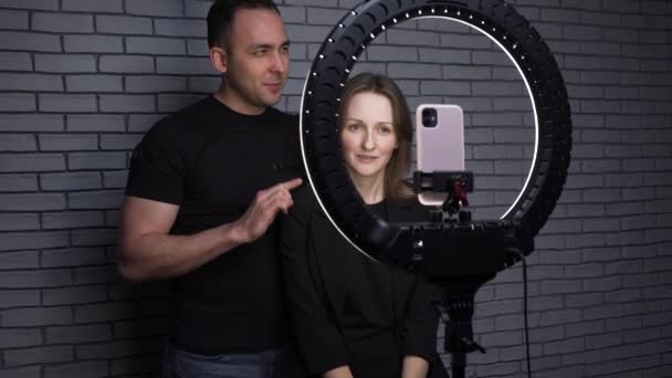 Βίντεο από ζευγάρι blogger με λάμπα δακτυλίου σε φόντο από τούβλα — Αρχείο Βίντεο