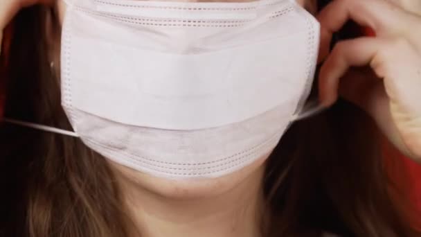 Video de niña vestirse de blanco máscara médica sobre fondo rojo — Vídeo de stock