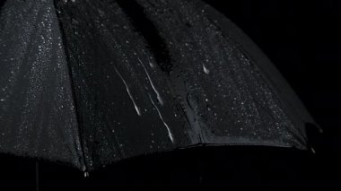 Siyah şemsiye ve yağmur damlalarının yavaş çekim yakın çekim videosu