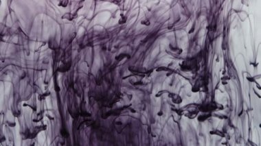 Suya düşen mor mürekkep damlalarının dokusu