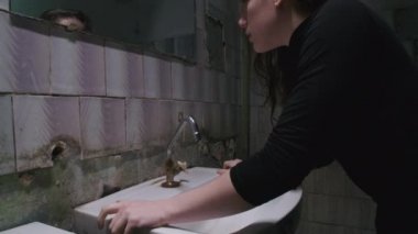 Zavallı banyoda genç bir kadının ağır çekim çekimi.