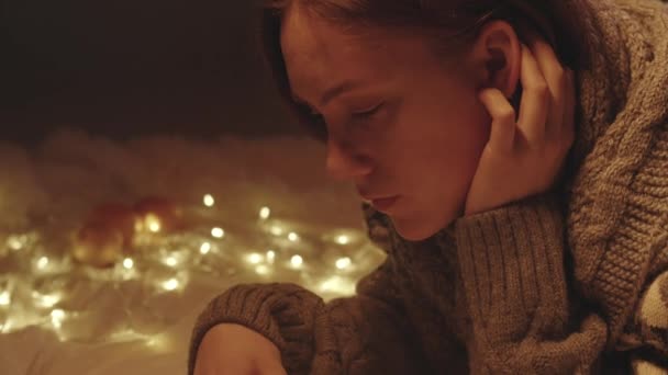 Footage of reading young woman in knitted sweater eating tangerine — Stock Video